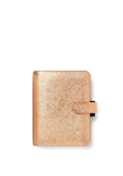 Affirmez votre style avec l'agenda de poche Saffiano métallisé or rose. Ce modèle d'exception, issu d'une collection prisée, se pare de reflets métalliques et offre des fonctionnalités pratiques : calendrier, intercalaires, carnet d'adresses et de nombreuses poches. Un passant élastique pour stylo apporte la touche finale élégante à cet agenda.