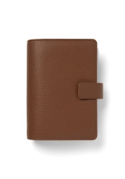Organizer Camden Personal w kolorze Mocha to stylowy i ekologiczny wybór dla wszystkich potrzeb związanych z planowaniem. Wykonany z wegańskiej skóry i wypełniony w 100% papierem pochodzącym z recyklingu, który jest przyjazny dla pióra wiecznego, oferuje innowacyjne funkcje, takie jak zdejmowana oprawa pierścieniowa charcoal, zapewniająca najwyższą elastyczność. Dzięki efektownemu wyglądowi skóry licowej, ten ekologiczny organizer na nowo definiuje funkcjonalność, jednocześnie utrzymując porządek w Twoim stylu życia.